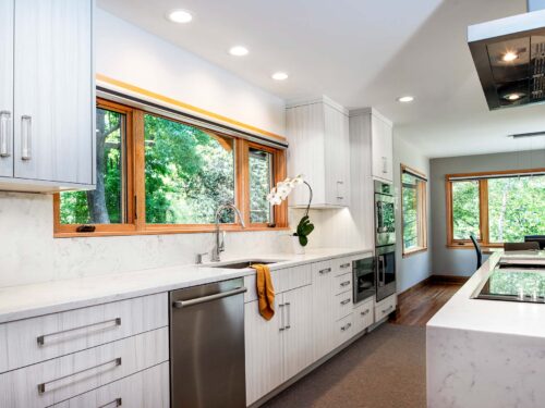 Tulsa kitchen design and remodel featuring white marble counters and backsplash, a stainless steel clean-up sink, a Bosch stainless front dishwasher, a Bosch under-counter drawer microwave, and Bosch professional stainless steel ovens.
