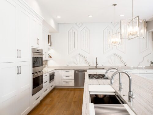 Tulsa kitchen remodel featuring double ovens, a drawer microwave, a Galley Workstation, a gas cooktop, and a large island with pendant lights and a deco wall.