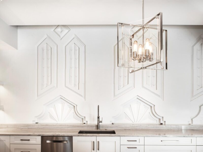 Tulsa kitchen remodel featuring an Art Deco wall carving, a clean-up sink, a stainless steel dishwasher, and a pendant light.