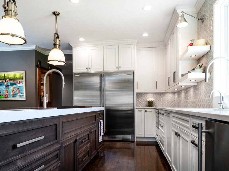 Tulsa kitchen remodel featuring a large island with base drawer storage, an Electrolux stainless steel full-size refrigerator and freezer, a Galley Workstation, a clean-up sink, open shelves, and pendant lights.