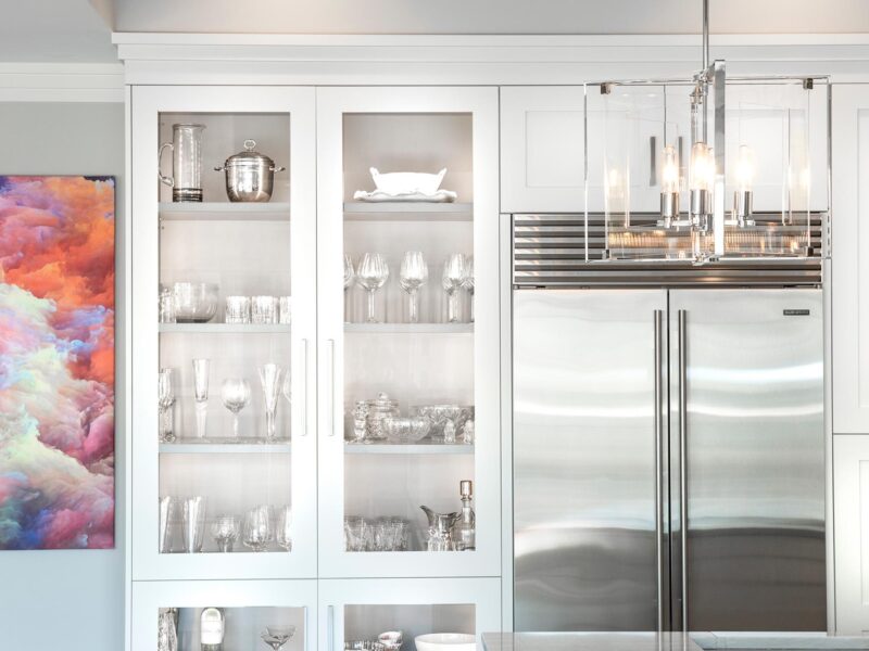 Tulsa kitchen remodel featuring a tall white pantry storage unit, a stainless steel Sub-Zero refrigerator and freezer, and a decorative pendant light.