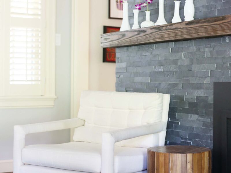 Traditional brick fireplace featuring wood mantle with wall-mounted television above, complemented by hardwood flooring in Tulsa kitchen renovation.