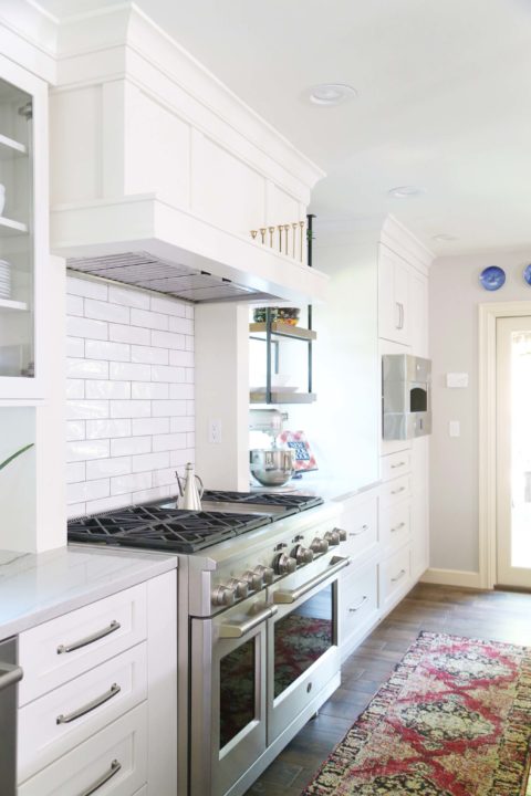 Kitchen gas range, decorative vent hood, Monogram hearth pizza oven, white cabinets, subway tile backsplash Kitchen Ideas Tulsa kitchen remodel