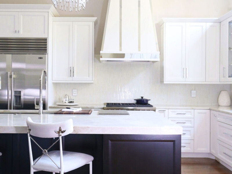 Tulsa kitchen design and remodel featuring a decorative Sub-Zero and Wolf vent hood, a professional gas range, full-size side-by-side freezer and refrigerator, a decorative tile backsplash, and an island with a Galley Workstation.