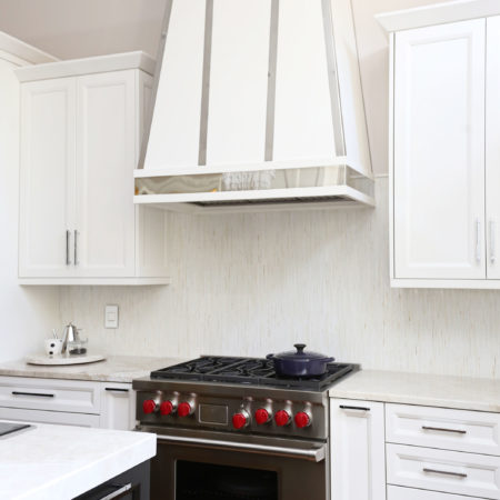 Kitchen Wolf professional range with decorative hood, tile backsplash, white cabinet storage, base wall storage Tulsa kitchen design and remodel