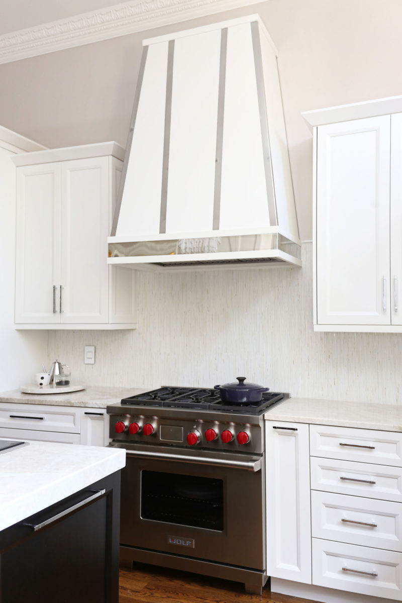 Kitchen Wolf professional range with decorative hood, tile backsplash, white cabinet storage, base wall storage Tulsa kitchen design and remodel