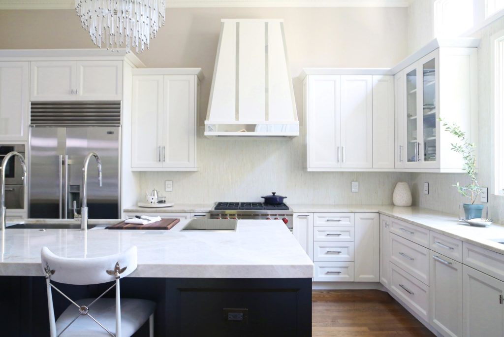 Timeless elegant large south Tulsa kitchen with large island brown cabinets, Galley Workstation and induction cooktop, stainless professional appliances and white wall cabinets