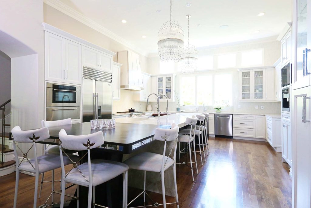 Timeless elegant large south Tulsa kitchen with large island, Galley Workstation, stainless appliances, wood floors and white cabinets
