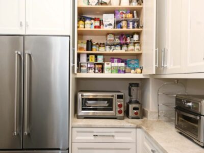Tulsa kitchen remodel featuring a walk-in pantry with extensive storage, a stainless steel french door refrigerator, wall spice storage, white cabinets, and a countertop with a toaster oven.