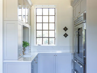 Bright kitchen beverage space with Sub-Zero professional refrigerator freezer, full height base storage, crown molding Tulsa kitchen remodel