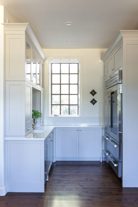 Bright kitchen beverage space with Sub-Zero professional refrigerator freezer, full height base storage, crown molding Tulsa kitchen remodel
