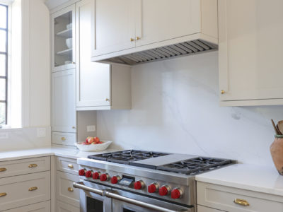 Bright kitchen Wolf range, counter slab backsplash, cabinet vent insert and drawer storage Tulsa kitchen remodel