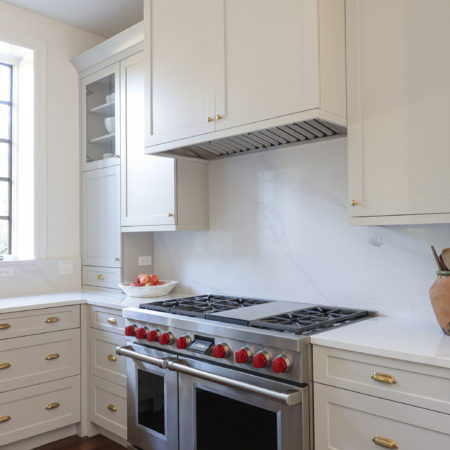 Bright kitchen Wolf range, counter slab backsplash, cabinet vent insert and drawer storage Tulsa kitchen remodel