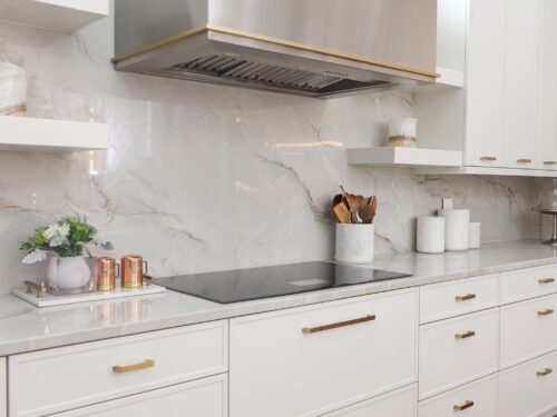 Tulsa kitchen remodel featuring a Dacor cooktop with a matching vent hood, a seamless countertop and backsplash, and built-in drawer storage.