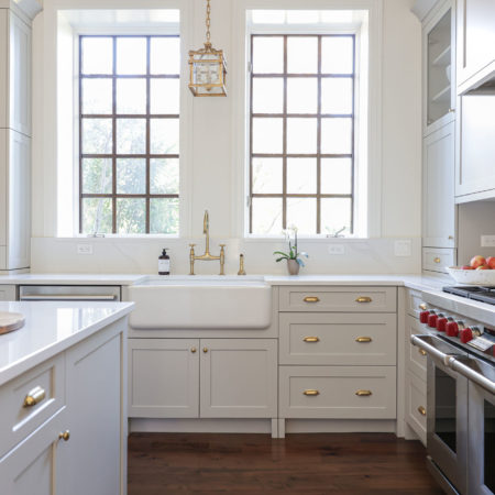 Kitchen island gas range bright cabinets wood floors farmhouse sink gold hardware Tulsa kitchen remodel