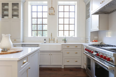 Kitchen island gas range bright cabinets wood floors farmhouse sink gold hardware Tulsa kitchen remodel