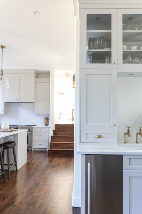 Open kitchen beverage space with wood floors, under counter ice maker, bar sink, white cabinets with glass fronts Tulsa kitchen design remodel