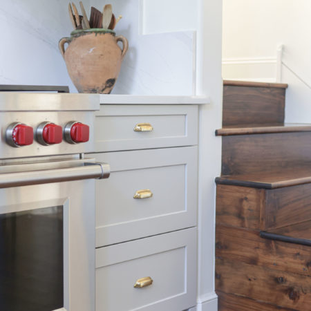 Spice drawer storage and Wolf professional gas range, white cabinets, wood floors, under cabinet LED puck lighting Tulsa kitchen remodeler