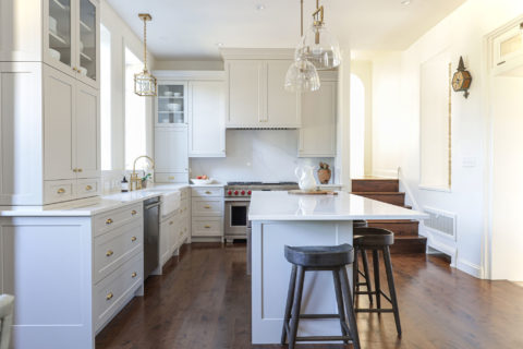 White kitchen remodel with island seating, pendant lighting, farmhouse apron-sink, Wolf gas range, drawer door storage kitchen ideas Tulsa kitchen designer