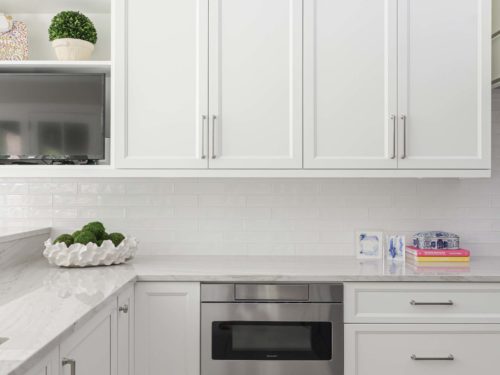 Tulsa kitchen remodel featuring a drawer microwave, white cabinets, open shelving, a subway tile backsplash, and large crown molding.