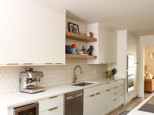 Tulsa kitchen remodel featuring flat-front door and drawer storage, white counters, an under counter beverage refrigerator, a dishwasher, an under mount sink, and floating shelves.