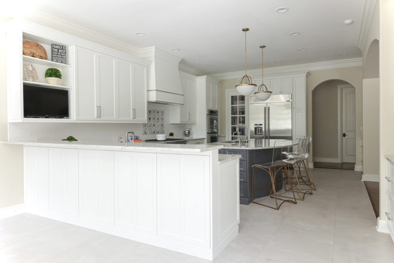 Kitchen peninsula, cabinet storage, large island with pendant lights, seating, decorative hood, rangetop, Jenn-air and Kitchenaid appliances, arched opening Kitchen Ideas Tulsa kitchen design remodel