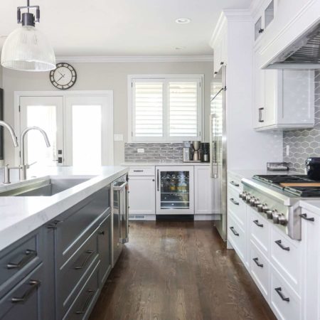 Gray white kitchen cabinets, island, Galley Workstation, pendants, quartz counters, wood floors, rangetop, tile backsplash Tulsa kitchen remodel