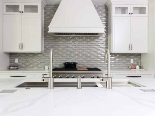 Tulsa kitchen remodel featuring a Galley Workstation, a gas range top, a vent hood, and a decorative backsplash in a "tuxedo" kitchen design.