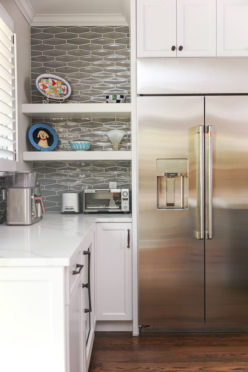 Open white kitchen shelves, white cabinets, quartz counters, stainless refrigerator, decorative tile backsplash Tulsa kitchen remodel