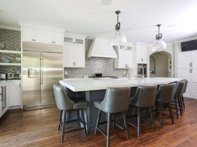 Two tone kitchen cabinetry, island seating, pendants, stainless appliances, wood floors, decorative backsplash Tulsa kitchen design and remodel