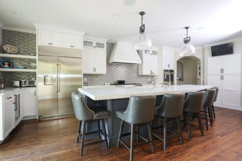 Two tone kitchen cabinetry, island seating, pendants, stainless appliances, wood floors, decorative backsplash Tulsa kitchen design and remodel