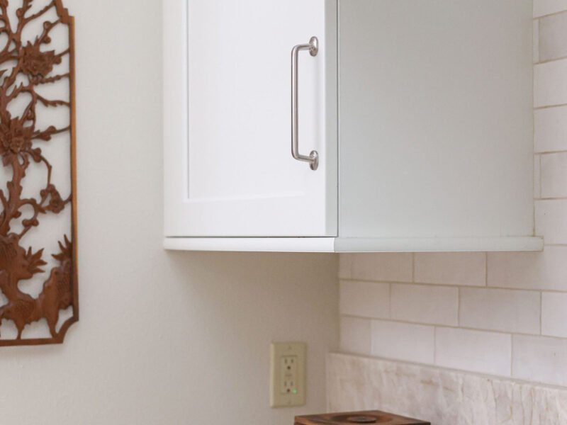 Tulsa kitchen remodel featuring white cabinet storage, quartz countertops, a gas cooktop, and a subway tile backsplash with a vent hood.
