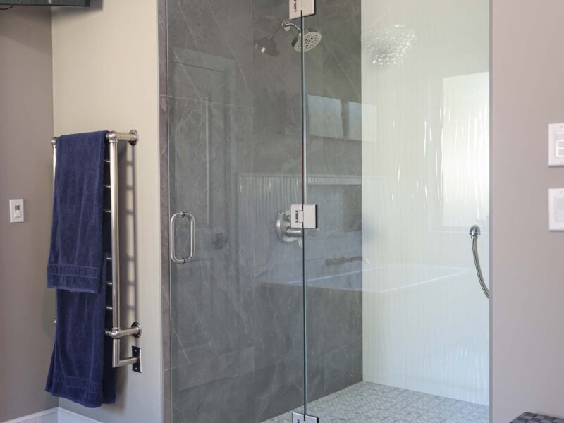 Modern walk-in shower featuring slate tile flooring in a Tulsa master bathroom renovation with contemporary design elements.