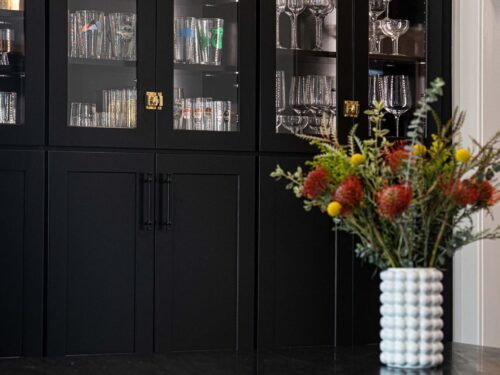 Tulsa kitchen design and remodel featuring a tall black storage cabinet with glass doors at top.
