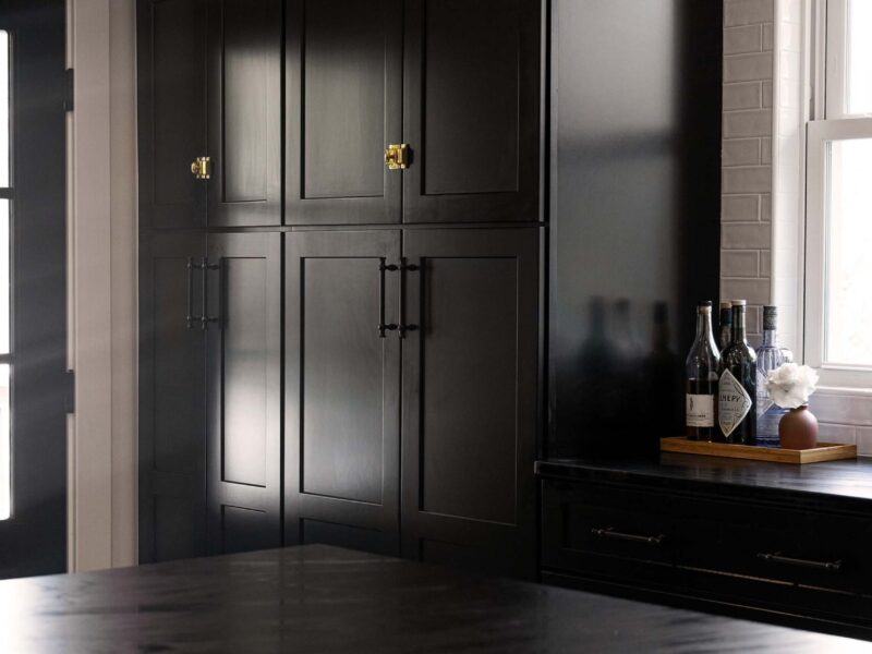 Tulsa kitchen remodel featuring black countertops, a glossy white subway tile backsplash, and extensive pantry and drawer storage.