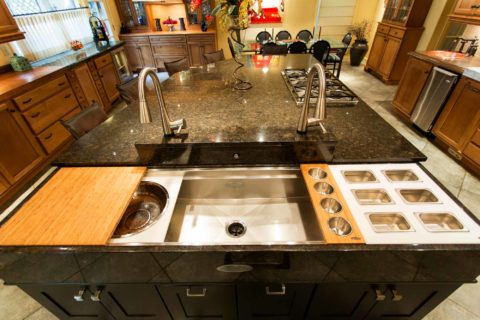 Tulsa kitchen design and remodel featuring a Galley kitchen workstation with accessories, an island with drawer storage, and a marble counter.