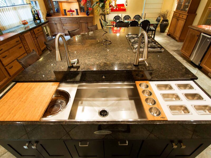 Tulsa kitchen design and remodel featuring a Galley kitchen workstation with accessories, an island with drawer storage, and a marble counter.