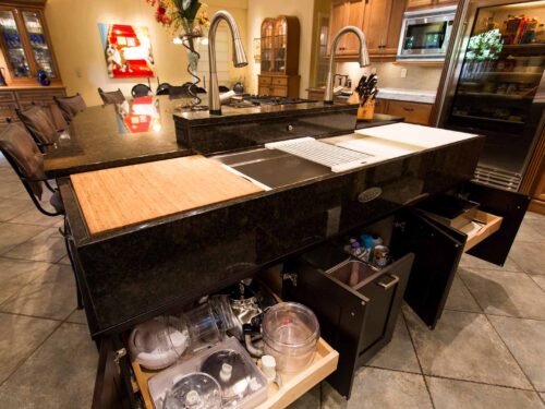 Tulsa kitchen design and remodel featuring an old-world kitchen with an island, a Galley Workstation, and dark cabinet pull-out accessory storage.