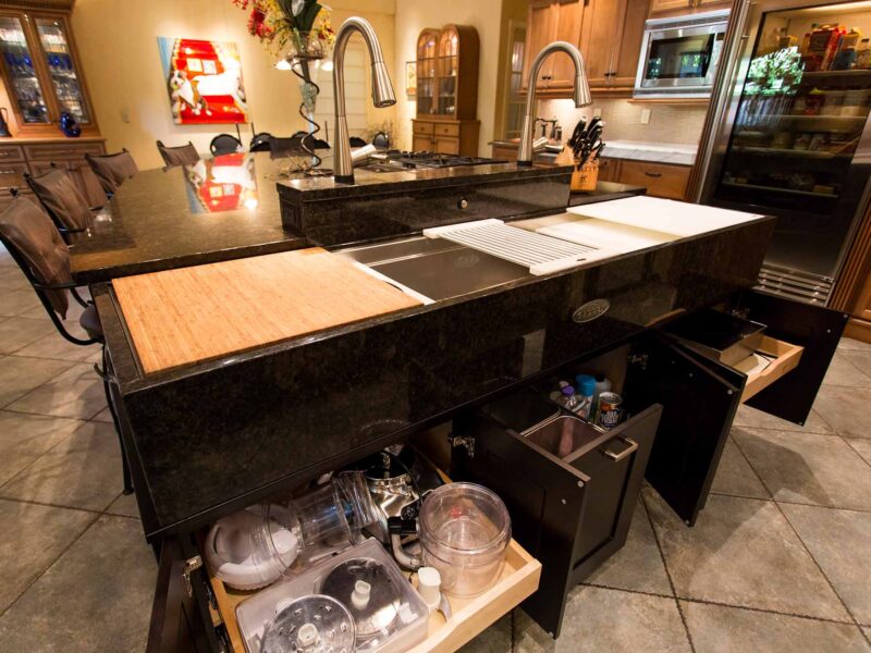 Tulsa kitchen design and remodel featuring an old-world kitchen with an island, a Galley Workstation, and dark cabinet pull-out accessory storage.