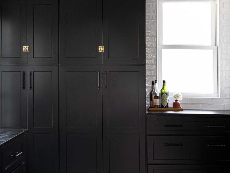 Tulsa kitchen remodel featuring a tall black pantry and drawer storage, with a glossy white subway tile backsplash.