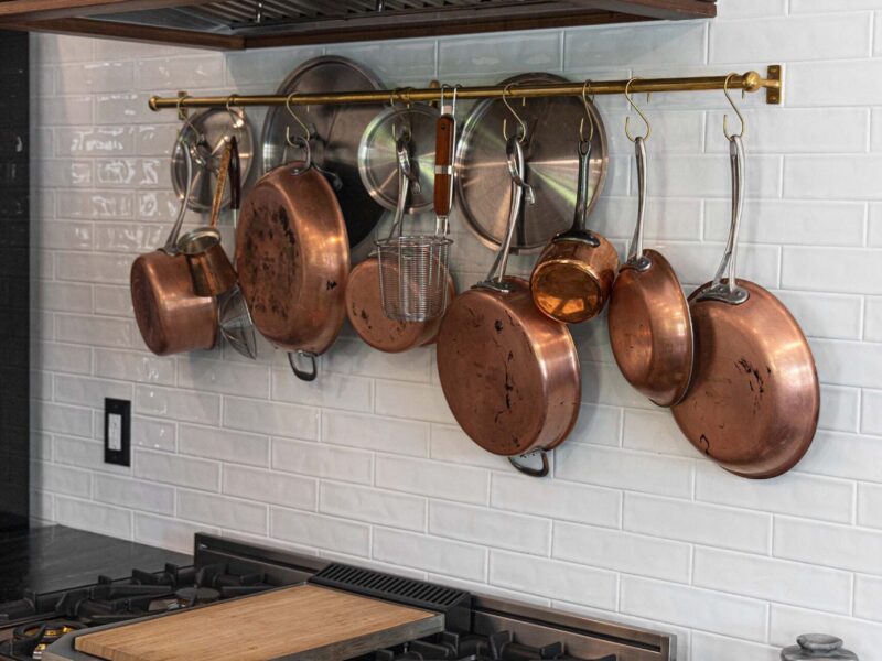 Tulsa kitchen design and remodel featuring a french range, a decorative vent hood, a plate rack, and a glossy white subway tile backsplash.