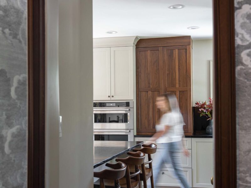 Tulsa kitchen remodel featuring an open entry, a large island with seating and built-in cabinet storage, appliances, and wood flooring.