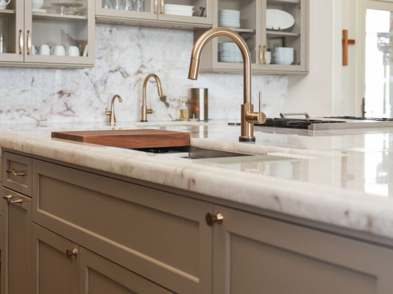 Tulsa kitchen remodeler showcasing a kitchen island with an ogee edge countertop and a Galley workstation, complete with a matching countertop backsplash and kitchen cabinet storage.