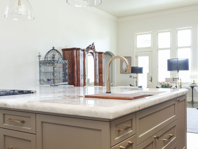 Tulsa kitchen remodeler showcasing a kitchen island with an ogee edge countertop, a Galley Workstation, and decorative pendant lights, along with surrounding kitchen cabinet storage.