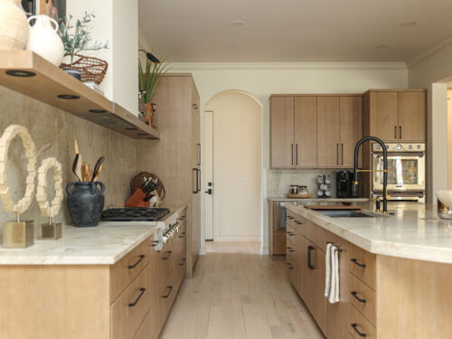 Tulsa kitchen remodel featuring oak cabinets, a large island with thick countertops, a gas rangetop, and ovens.