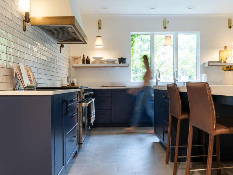 Tulsa kitchen remodel featuring a minimalist design with a warm color palette, rich blue cabinets, and wood tones. The space is centered around a large kitchen island.