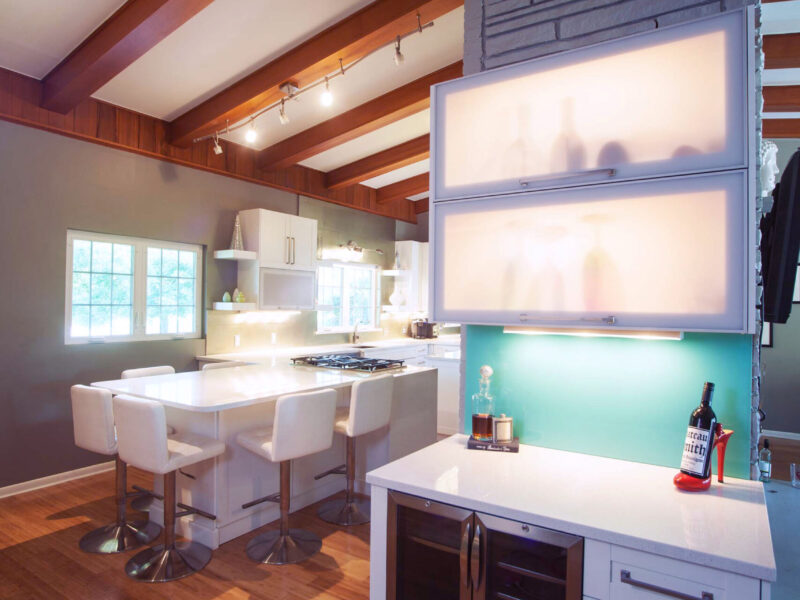 Tulsa kitchen remodel featuring a beverage bar with frosted glass wall cabinets, a built-in wine and beverage refrigerator, and a vaulted ceiling with a stone accent wall.