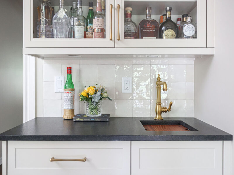 Custom kitchen bar with a sink and black counters. A tile backsplash completes the design. Tulsa kitchen design and remodel.