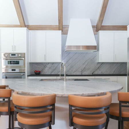 Tulsa kitchen design and remodel featuring a round island with seating, stainless steel appliances, and a counter-to-ceiling backsplash.