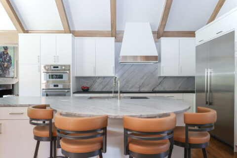 Tulsa kitchen design and remodel featuring a round island with seating, stainless steel appliances, and a counter-to-ceiling backsplash.